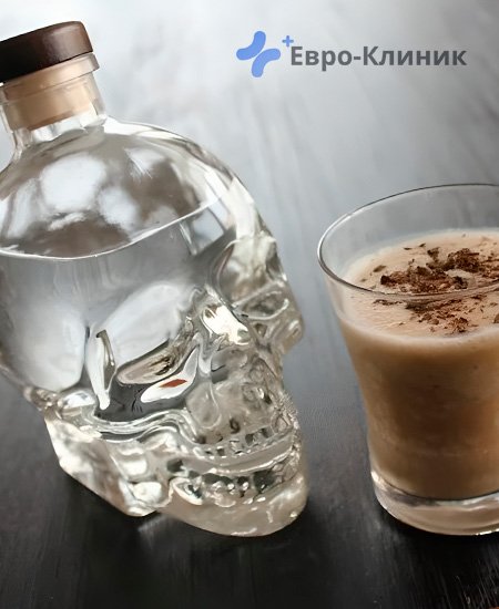 стакан с кофе и бутылка с алкоголем на столе